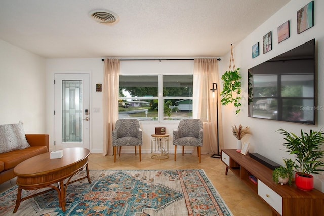 sitting room with light tile patterned flooring and a textured ceiling