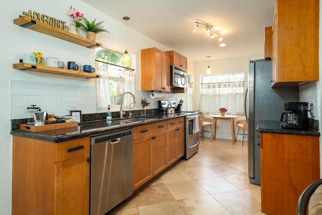 kitchen featuring tasteful backsplash, pendant lighting, appliances with stainless steel finishes, and a wealth of natural light