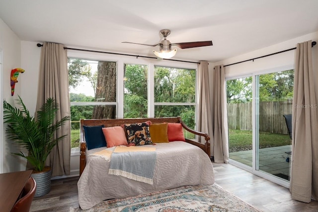 bedroom with hardwood / wood-style flooring, ceiling fan, access to exterior, and multiple windows