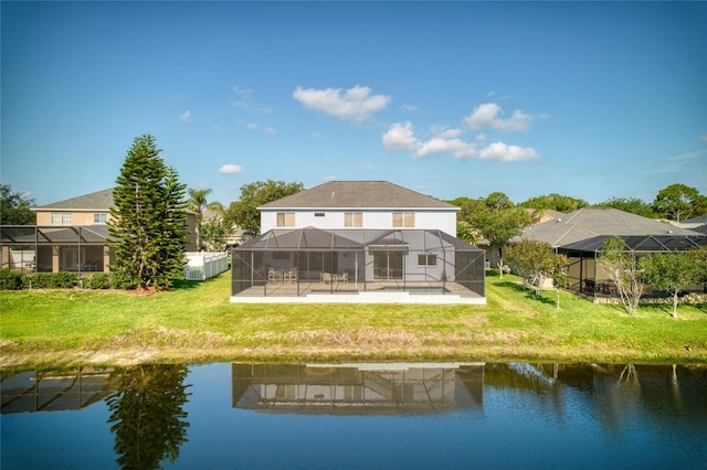 rear view of house with glass enclosure, a yard, a patio, and a water view