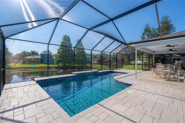 pool featuring a water view, outdoor dining area, a patio area, a ceiling fan, and glass enclosure