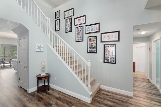 staircase with baseboards and wood finished floors