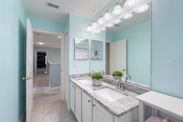 full bath featuring a sink, baseboards, double vanity, and visible vents