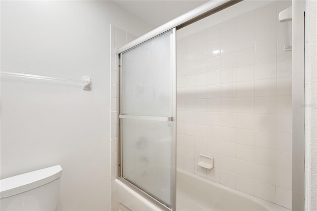 bathroom featuring toilet and enclosed tub / shower combo