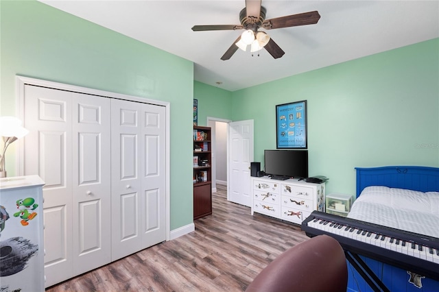 bedroom with a closet, baseboards, ceiling fan, and wood finished floors