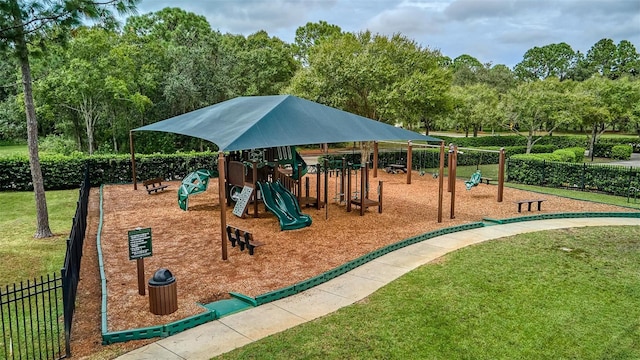 community jungle gym with a lawn and fence