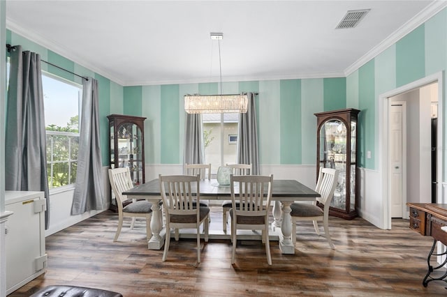 dining area with plenty of natural light, ornamental molding, and wallpapered walls