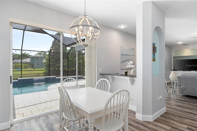 dining room with baseboards, wood finished floors, and a chandelier