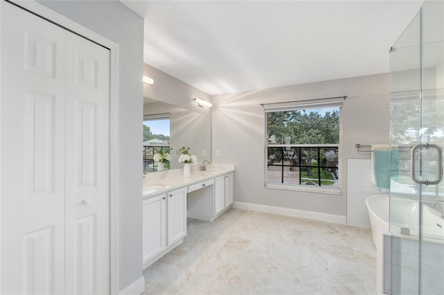 bathroom featuring a freestanding bath, double vanity, marble finish floor, baseboards, and a stall shower