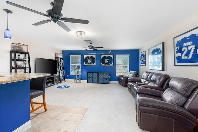 living room with light colored carpet, baseboards, ceiling fan, and visible vents