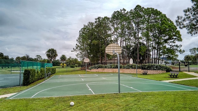 view of basketball court featuring fence, a yard, and community basketball court