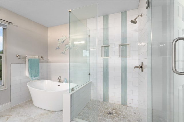full bath with a freestanding tub, tile walls, a shower stall, and tile patterned floors