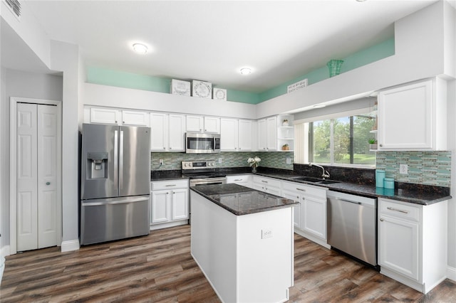kitchen with white cabinets, open shelves, appliances with stainless steel finishes, a sink, and backsplash