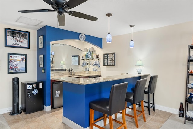 bar with a sink, baseboards, indoor wet bar, and a ceiling fan