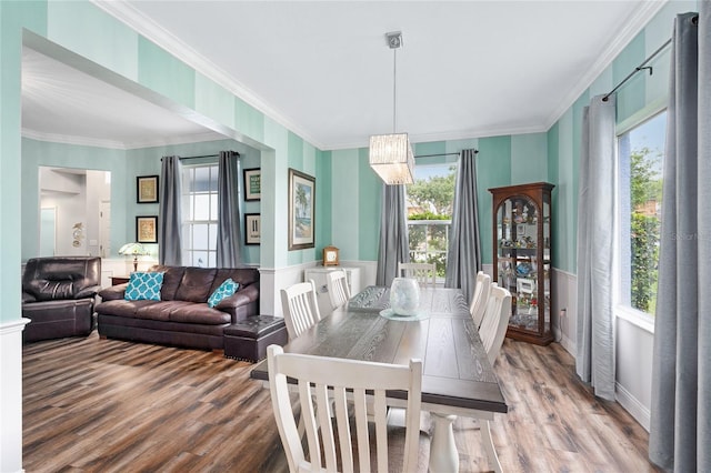 dining space featuring plenty of natural light, baseboards, ornamental molding, and wood finished floors