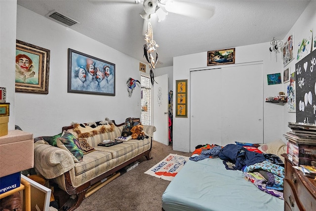 carpeted bedroom featuring ceiling fan, a textured ceiling, and a closet