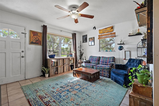 living area featuring a textured ceiling, ceiling fan, and tile patterned floors