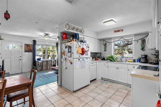 kitchen featuring white appliances, light countertops, a textured ceiling, white cabinetry, and a ceiling fan