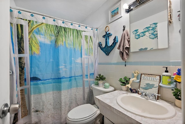 bathroom with tile walls, vanity, toilet, and a shower with shower curtain
