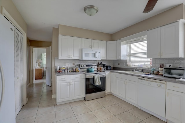 kitchen featuring tasteful backsplash, white cabinetry, sink, and white appliances