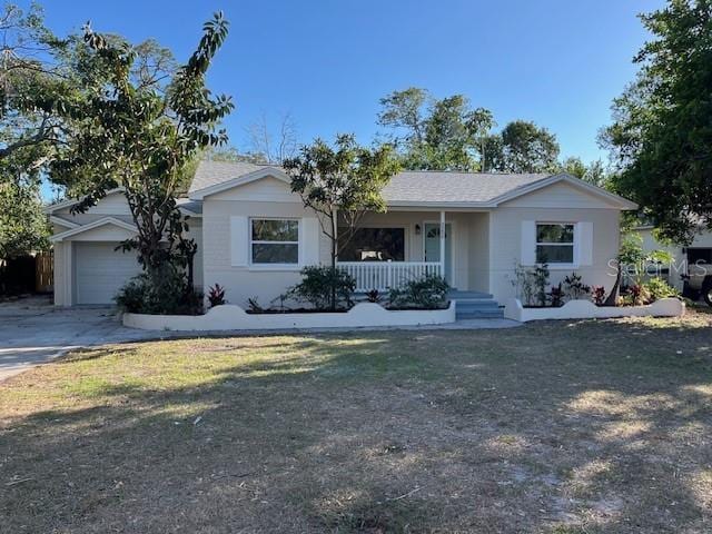 ranch-style house featuring a garage, a front yard, and covered porch