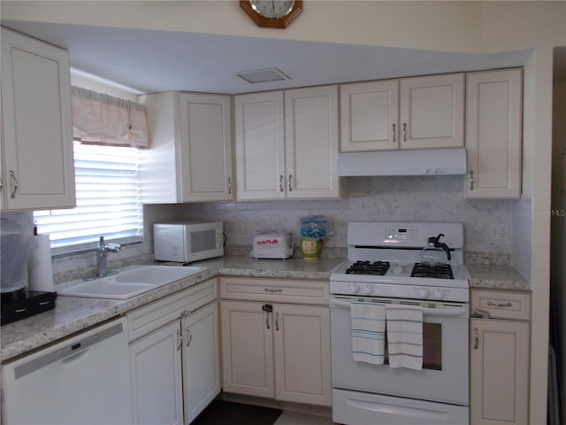 kitchen featuring tasteful backsplash, white cabinetry, sink, and white appliances