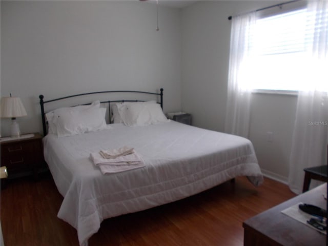 bedroom with dark hardwood / wood-style floors