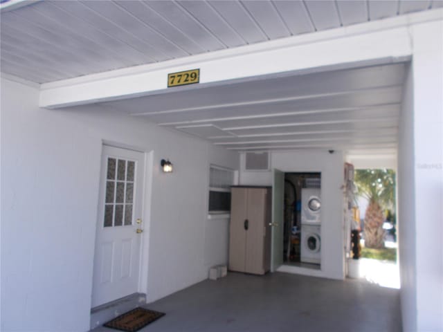 garage featuring stacked washer and clothes dryer