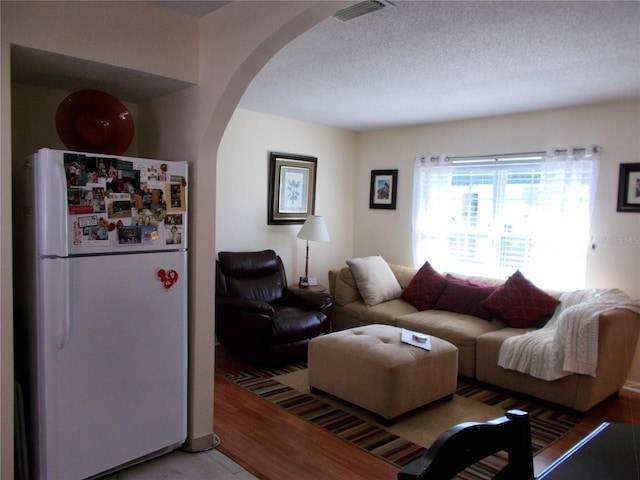 living room featuring wood-type flooring and a textured ceiling