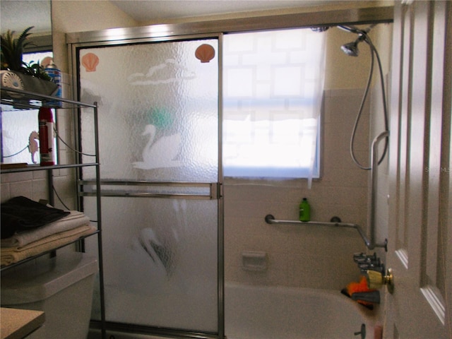 bathroom featuring bath / shower combo with glass door and toilet