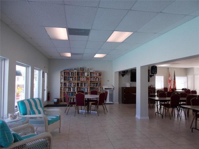 tiled dining room with a drop ceiling