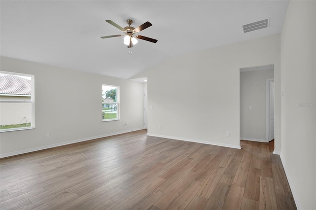 empty room with lofted ceiling, ceiling fan, and light hardwood / wood-style flooring