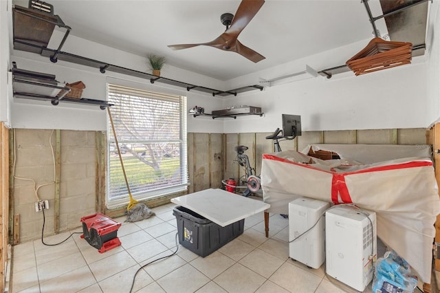 basement featuring ceiling fan and light tile patterned floors