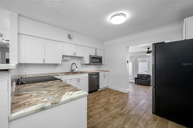 kitchen with sink, white cabinetry, stainless steel appliances, decorative backsplash, and light wood-type flooring