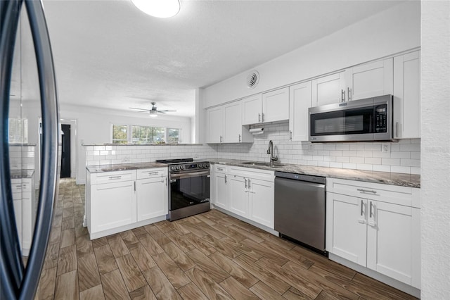 kitchen with white cabinetry, sink, backsplash, and appliances with stainless steel finishes