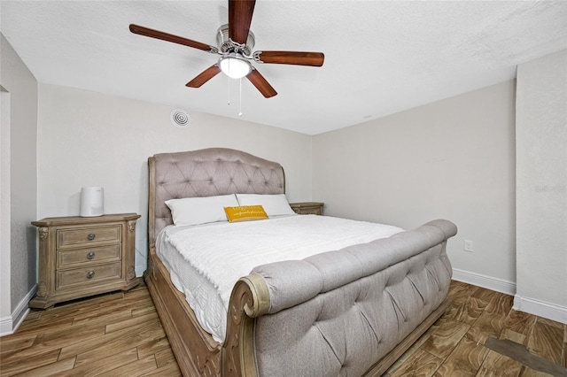 bedroom featuring hardwood / wood-style flooring, a textured ceiling, and ceiling fan