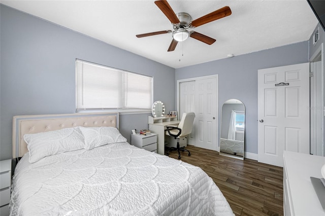 bedroom with a closet, dark hardwood / wood-style floors, and ceiling fan