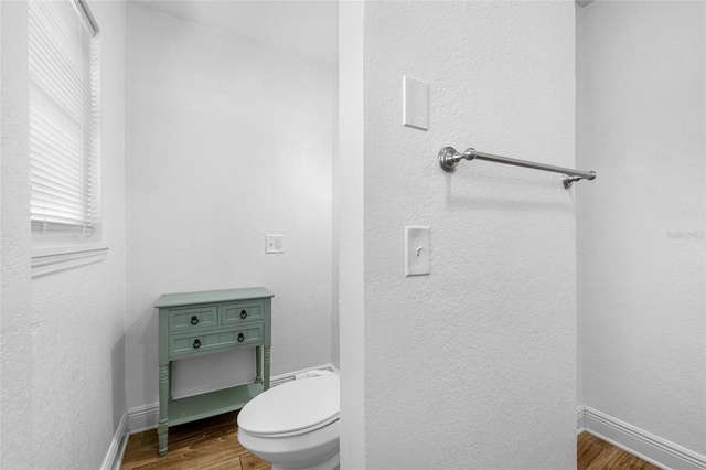 bathroom with hardwood / wood-style flooring and toilet