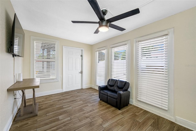 sitting room with wood-type flooring and ceiling fan