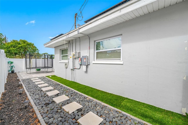 view of home's exterior featuring a trampoline and a patio