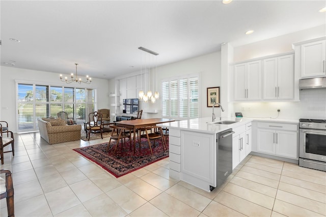 kitchen with appliances with stainless steel finishes, white cabinetry, hanging light fixtures, kitchen peninsula, and a chandelier