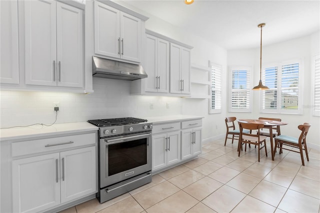 kitchen with pendant lighting, white cabinetry, decorative backsplash, light tile patterned floors, and gas stove