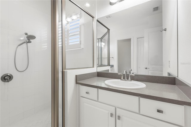 bathroom with vanity and a shower with shower door