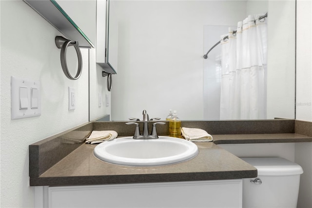 bathroom with vanity, toilet, and walk in shower