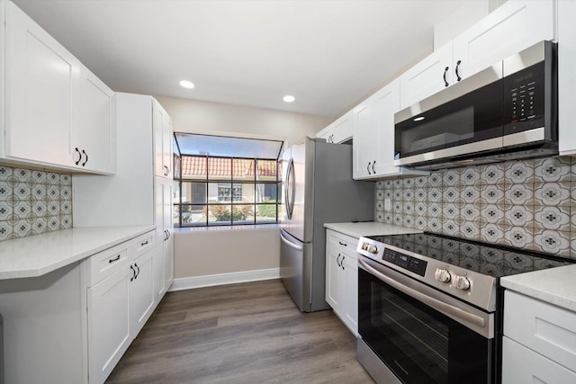 kitchen featuring appliances with stainless steel finishes, dark hardwood / wood-style floors, white cabinets, and decorative backsplash