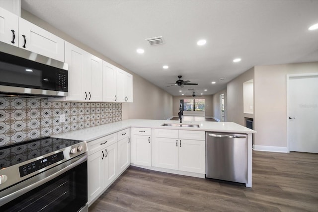 kitchen featuring white cabinetry, sink, stainless steel appliances, and kitchen peninsula