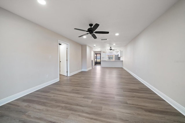 unfurnished living room with ceiling fan and hardwood / wood-style floors