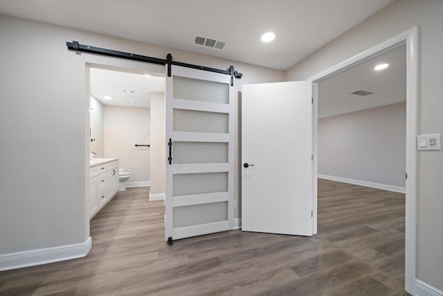 interior space featuring hardwood / wood-style floors and a barn door