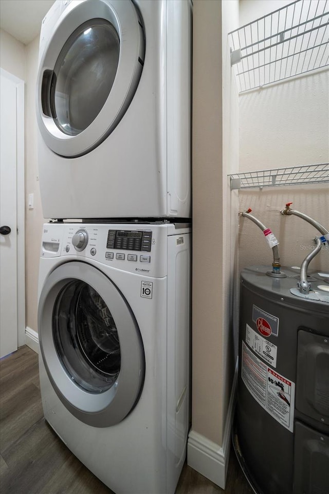 clothes washing area with stacked washer and dryer, dark hardwood / wood-style floors, and water heater