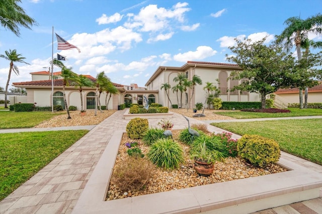 mediterranean / spanish-style home with a front lawn